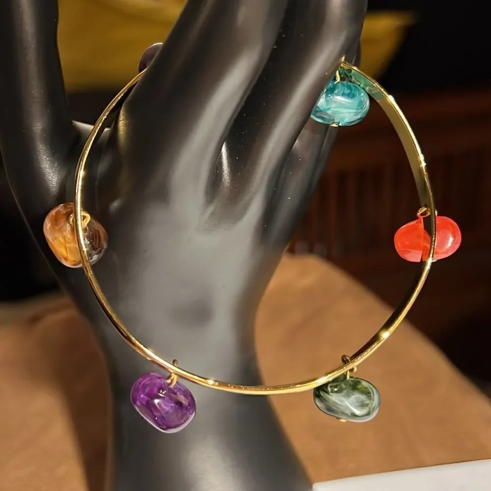 Gold tone bracelet with 6 colored gemstones.